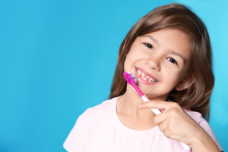 Young girl smiling with toothbrush